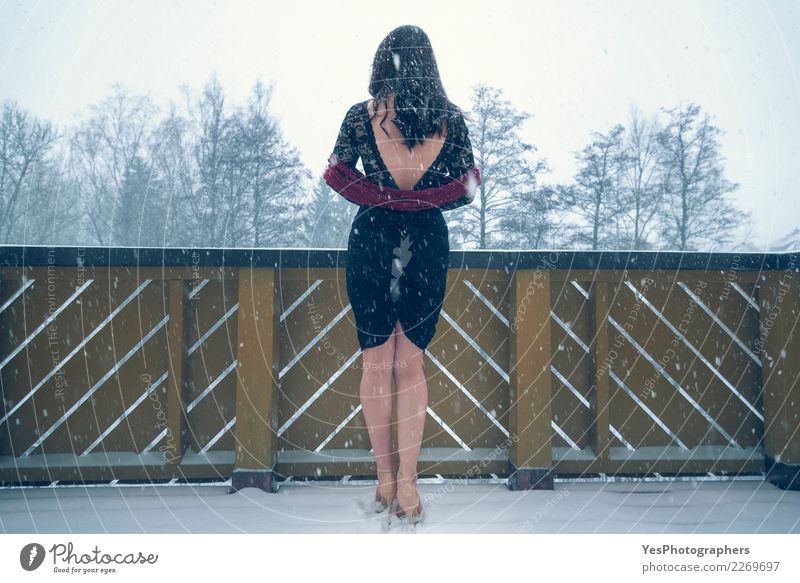 Sexy Frau im schwarzen Kleid unter Schneefällen elegant Silvester u. Neujahr Junge Frau Jugendliche Natur Schneefall Damenschuhe Denken Traurigkeit Einsamkeit