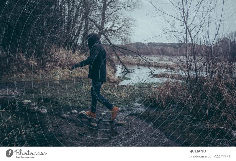 Junger Mann springt auf Felsen, um den Fluss zu kreuzen Freizeit & Hobby Ferien & Urlaub & Reisen Ausflug Abenteuer Winter Schnee Winterurlaub Mensch maskulin