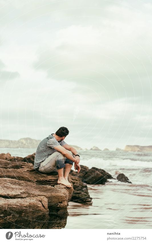 Mann, der nahe dem Meer an einem bewölkten Tag sitzt Lifestyle Wellness Wohlgefühl Sinnesorgane Erholung Ferien & Urlaub & Reisen Tourismus Abenteuer Ferne