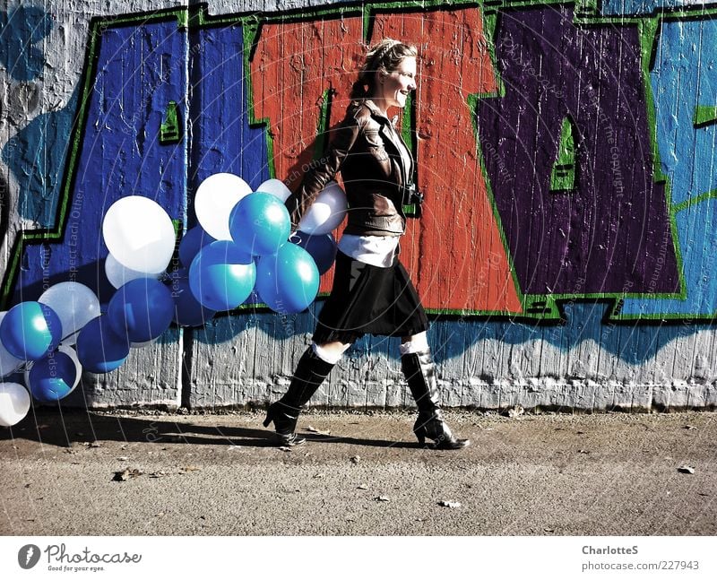 Catwalk Lifestyle feminin Junge Frau Jugendliche Schönes Wetter Mauer Wand Wege & Pfade Leder Stiefel Lederjacke Fotokamera rothaarig Luftballon Beton Zeichen