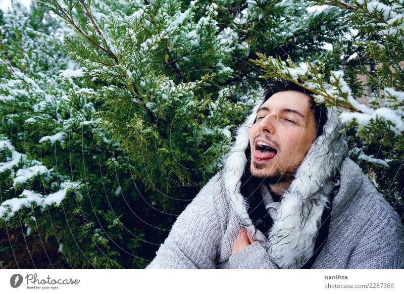 Junger Mann, der den Schnee an einem Wintertag genießt Lifestyle Stil Freude Wellness Leben Wohlgefühl Winterurlaub Mensch maskulin Jugendliche Erwachsene 1