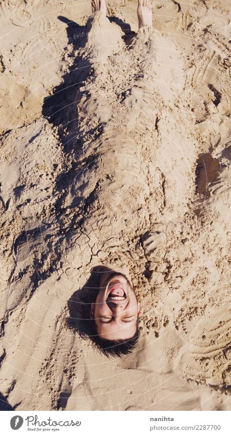 Junger Mann begraben im Sand Lifestyle Freude Ferien & Urlaub & Reisen Abenteuer Freiheit Sommer Sommerurlaub Sonne Strand Mensch maskulin Jugendliche