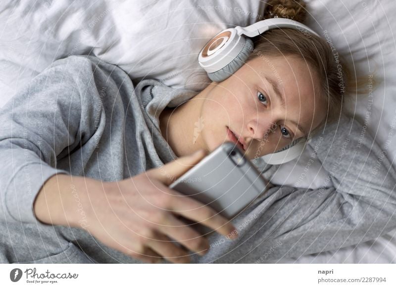 Chillen in Perfektion feminin Junge Frau Jugendliche 1 Mensch 13-18 Jahre Kopfhörer Handy Erholung hören liegen authentisch grau weiß Müdigkeit Freizeit & Hobby