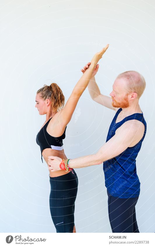 Yogaschüler, die verschiedene Yogahaltungen zeigen. Arm erhoben. Lehrer hilft Lifestyle Gesundheitswesen Fitness Erholung Windstille Meditation Sport Mensch