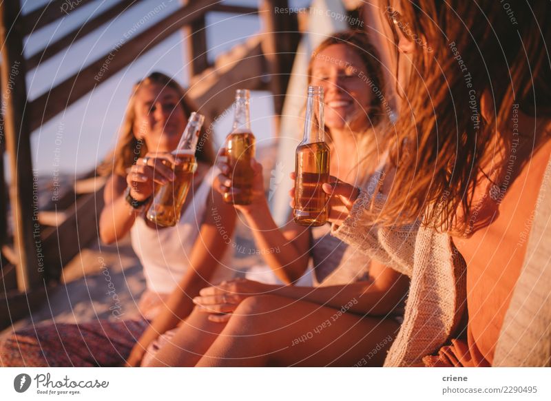 Junge erwachsene Freunde, die mit Bier im Sonnenuntergang am Strand rösten Flasche Freude Glück Ferien & Urlaub & Reisen Sommer Party ausgehen Feste & Feiern