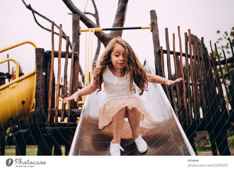 Kleines kaukasisches Mädchen, das Spaß auf Dia auf Spielplatz hat Lifestyle Freude Glück Spielen Kind Kindheit klein niedlich Gefühle kleines Mädchen Sliden