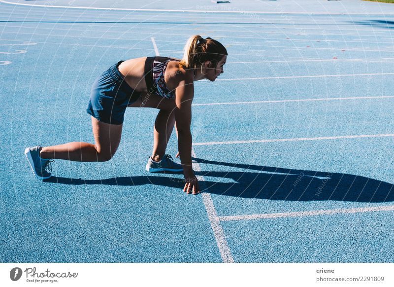 Geeigneter weiblicher Athlet, der auf Laufbahn sprintet Sport Mensch feminin Frau Erwachsene Fitness Geschwindigkeit blau Beginn rennen üben laufen bereit