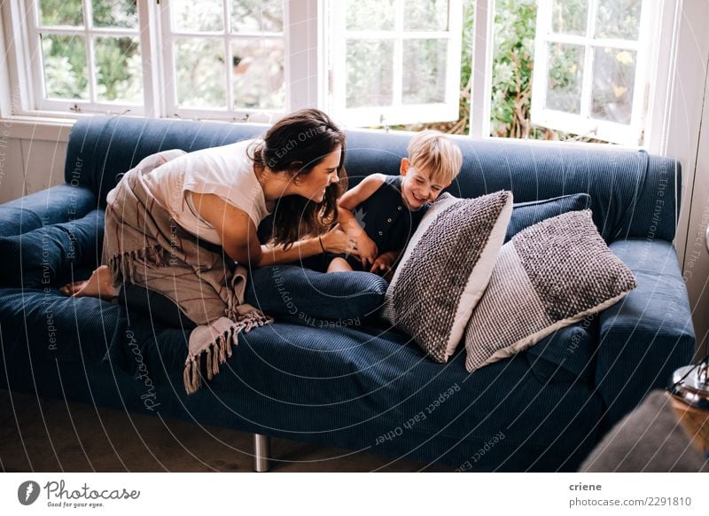 Glückliche Mutter und Kleinkind, die zu Hause auf Couch streichelt Kindererziehung Erwachsene Familie & Verwandtschaft Kindheit genießen Lächeln lachen