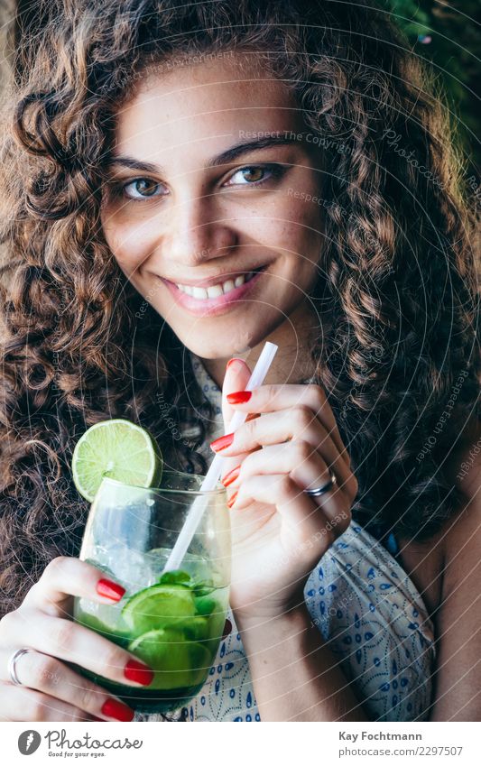 Lächelnde Brasilianerin mit einem Glas Caipirinha in der Hand Getränk Alkohol Longdrink Cocktail Lifestyle elegant Stil exotisch Glück schön Haare & Frisuren