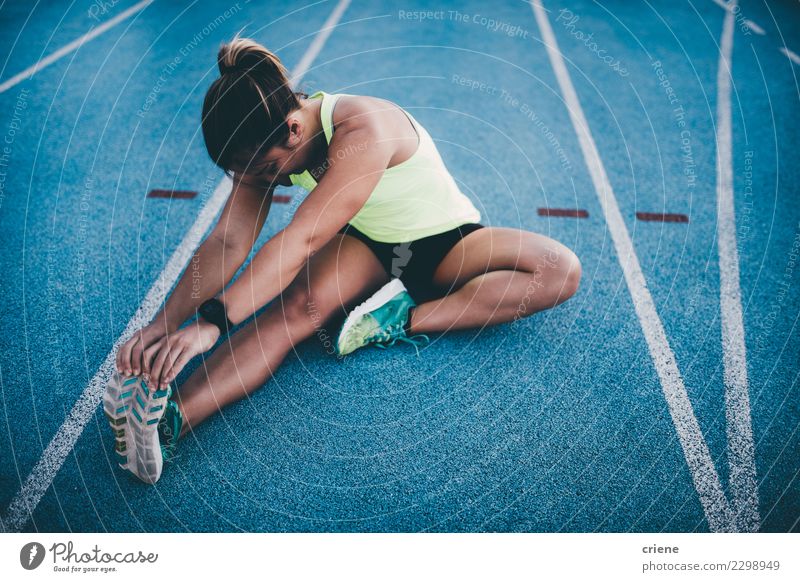 Weibliche athletische Frau, die nach laufendem Training ausdehnt Lifestyle Sport Leichtathletik Erfolg Joggen Stadion Rennbahn Mensch Erwachsene Konkurrenz