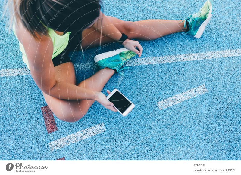 Weiblicher Athlet, der Telefon verwendet, um Training zu verfolgen Lifestyle Sport Leichtathletik Erfolg Joggen Stadion Rennbahn PDA Bildschirm