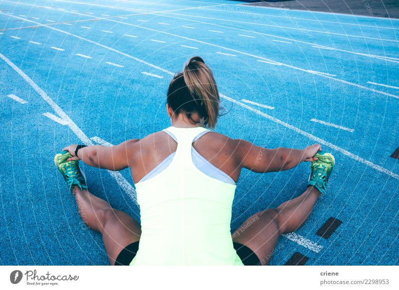 Weiblicher Athlet, der vor Training auf Laufbahn aufwärmt Lifestyle Sport Leichtathletik Erfolg Joggen Stadion Rennbahn Mensch Frau Erwachsene blau Konkurrenz