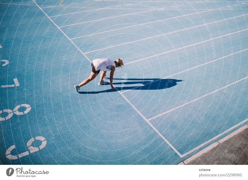 Kaukasischer weiblicher Athlet, der auf blauer Laufbahn läuft Lifestyle Sport Leichtathletik Erfolg Stadion Mensch Frau Erwachsene Schuhe Fitness Beginn