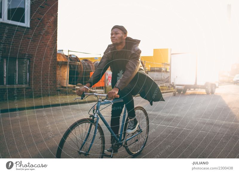 Junges modernes Hipster-Fahrrad durch die Stadt bei Sonnenuntergang. Stadtleben Großstadt Lifestyle Freiheit Abenddämmerung Turnschuh Verkehr Schickimicki