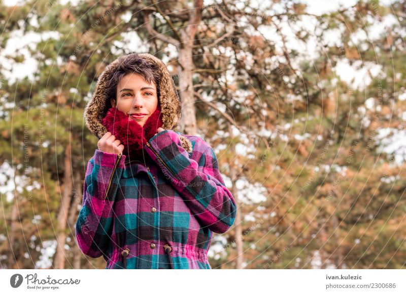 Nettes Brunettemädchen, das im Park, in tragendem Mantel und in Schal steht Lifestyle elegant Stil Glück schön Gesicht Winter Mensch Frau Erwachsene Natur