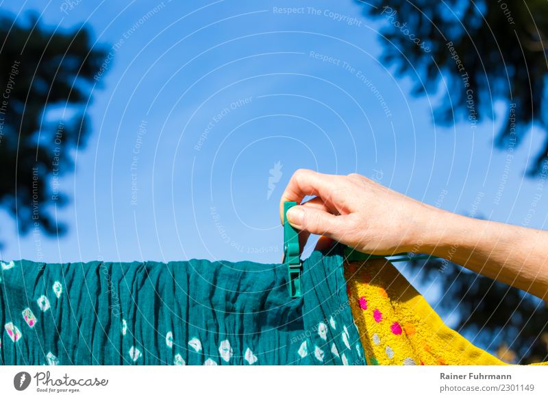 eine Frau hängt Wäsche zum trocknen auf eine Wäscheleine Wohnung Garten Mensch feminin Hand Reinlichkeit Sauberkeit Reinheit "waschen Hausarbeit