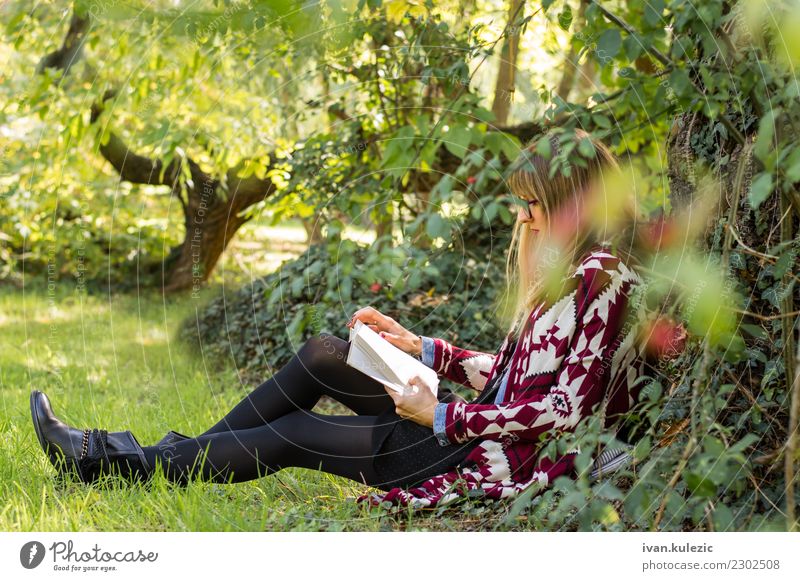 Mädchen, das unter dem Baum, das Buch lesend stationiert Lifestyle Glück schön Erholung Freizeit & Hobby Freiheit Sonne lernen Studium Frau Erwachsene Natur