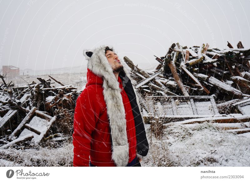 Junger Mann mit einem Pelzhut einen schneebedeckten Tag genießend Lifestyle Stil Freude Wellness harmonisch Winter Schnee Winterurlaub Mensch maskulin