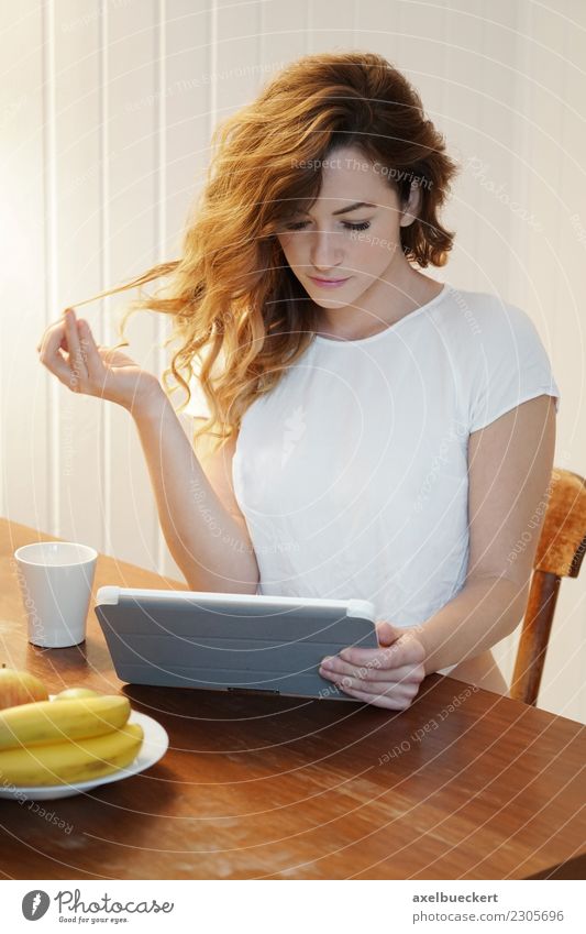 junge Frau mit Tablet Computer am Frühstückstisch Frucht Kaffee Lifestyle Erholung Freizeit & Hobby Häusliches Leben Wohnung Tisch Küche Entertainment Notebook