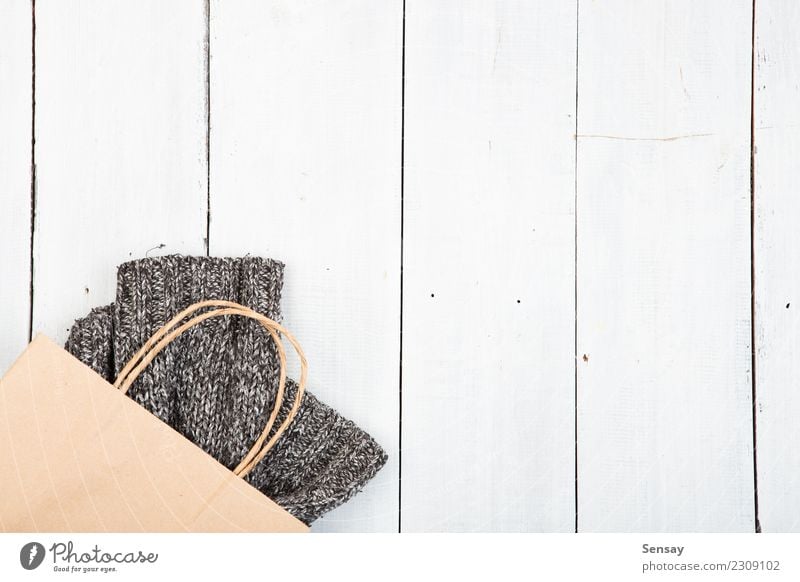 gestrickter Winterpullover auf Holzuntergrund Lifestyle kaufen Stil stricken Schreibtisch Tisch Industrie Herbst Wärme Mode Bekleidung Pullover Stoff weich grau