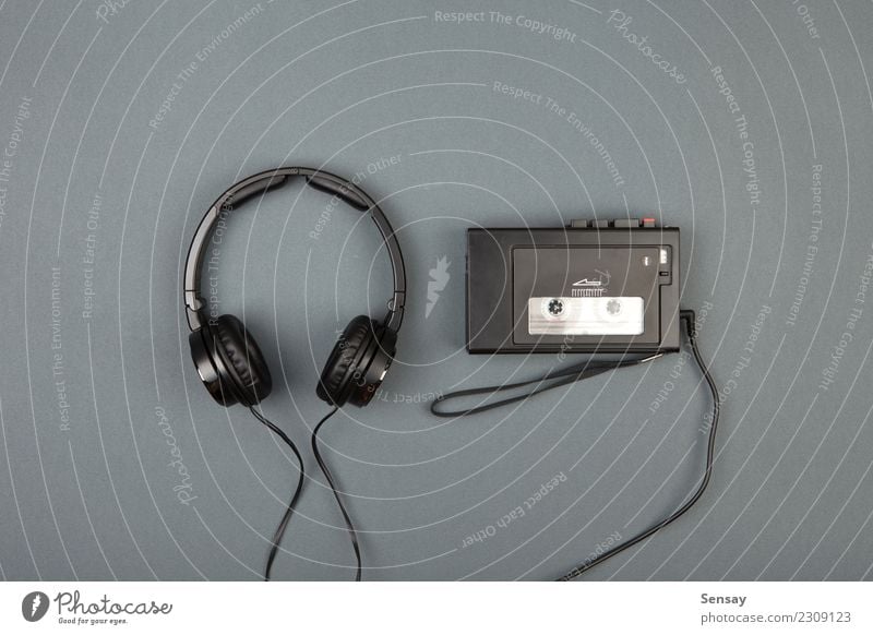 Retro-Kassettenspieler mit Kopfhörer auf grauem Hintergrund Stil Freizeit & Hobby Spielen Schreibtisch Musik Telefon Headset Technik & Technologie Felsen alt