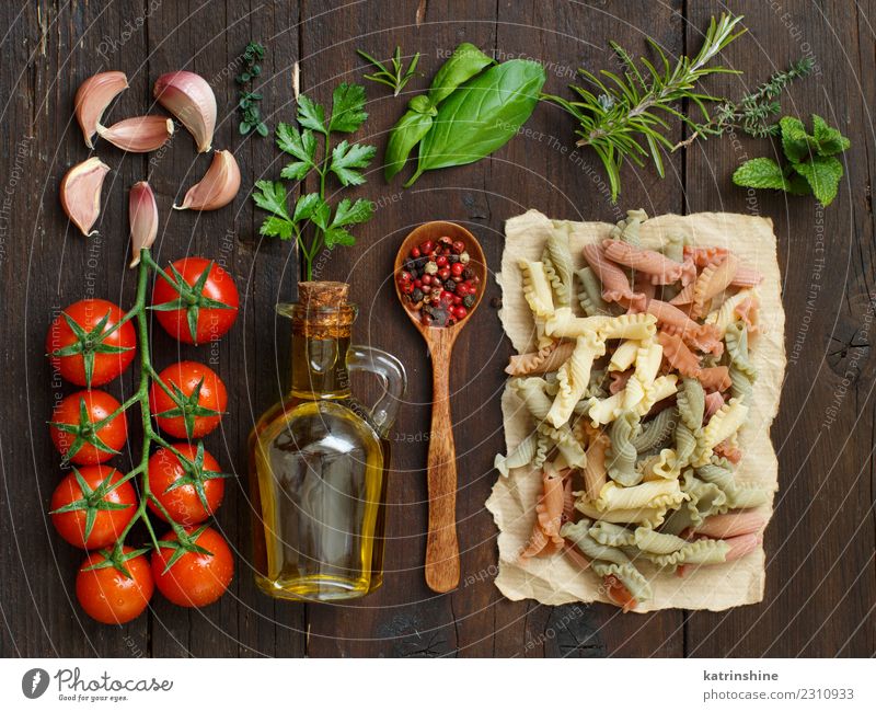 Dreifarbige Nudeln, Gemüse, Kräuter und Olivenöl Vegetarische Ernährung Diät Flasche Tisch dunkel frisch braun rot Tradition Essen zubereiten Lebensmittel