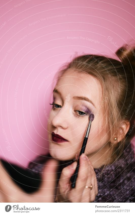 Young woman putting on make-up feminin Junge Frau Jugendliche Erwachsene 1 Mensch 18-30 Jahre schön Schminken violett Pinsel auftragen Spiegel rosa geschminkt