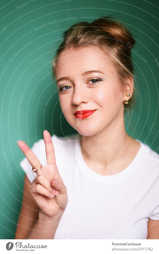 Young blonde woman showing the peace sign Junge Frau Jugendliche Erwachsene 1 Mensch 18-30 Jahre schön Frieden Zeichen Peacezeichen Friedenszeichen