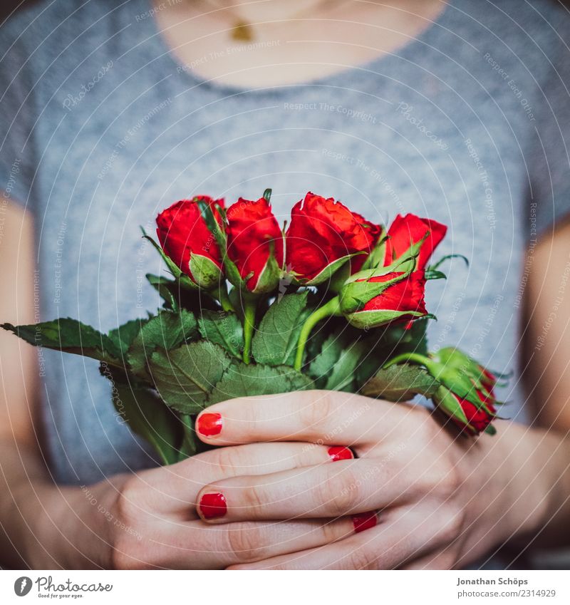 junge Frau hält Blumenstrauß aus roten Rosen in ihren Händen, Valentinstag, Muttertag, Geschenk Freude Erwachsene Freundschaft Hand festhalten Liebe Gefühle