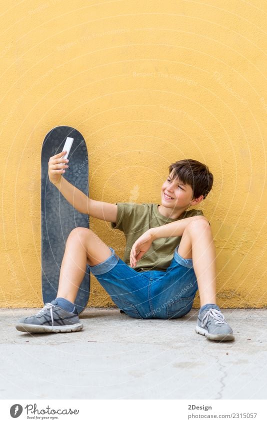 Junger Teenager Selfie mit Skateboard auf dem Boden sitzend Lifestyle Freude Erholung Freiheit Sommer Sonne Kind Funktelefon PDA Internet Mann Erwachsene