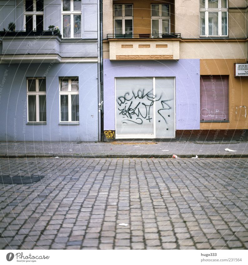 Berlin XII Neukölln Stadt Hauptstadt Menschenleer Haus Verkehrswege Straße Stein Graffiti Häusliches Leben blau rot Pflastersteine Rollladen Ladengeschäft