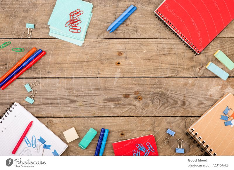 Notizbücher, Papiere, Marker und andere Schreibwaren auf Holztisch Design Tisch Kind Schule Klassenraum Büro Kindheit Kunst Accessoire blau rot schwarz