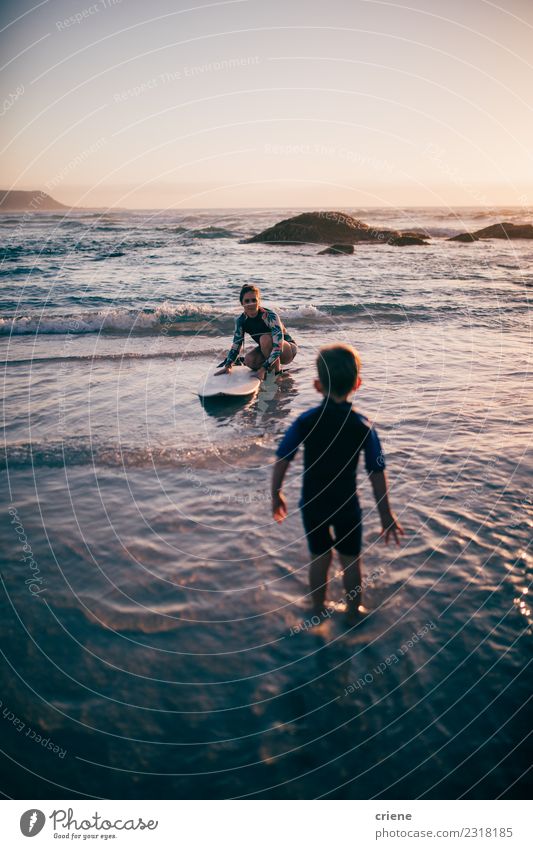 Mutter unterrichtet ihren Sohn beim Surfen mit dem Surfbrett. Lifestyle Freude Glück Erholung Freizeit & Hobby Ferien & Urlaub & Reisen Sommer Strand Meer Sport