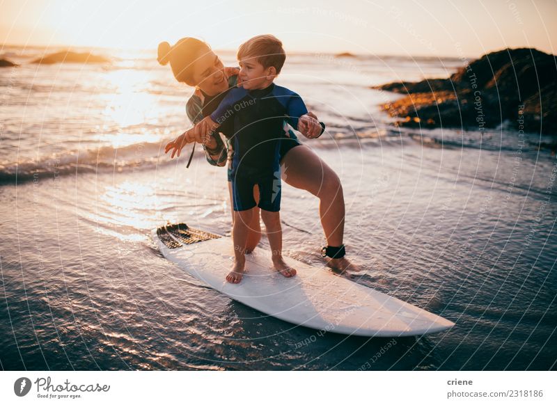 Kleiner Junge und Mutter üben das Surfen am Strand. Lifestyle Freude Glück Erholung Freizeit & Hobby Ferien & Urlaub & Reisen Sommer Meer Sport Kind Schule