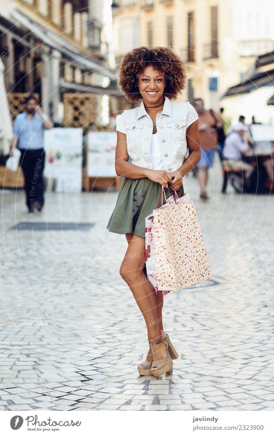 Schwarze Frau, Afro-Frisur, mit Einkaufstaschen auf der Straße Lifestyle kaufen Stil Haare & Frisuren Mensch feminin Junge Frau Jugendliche Erwachsene 1