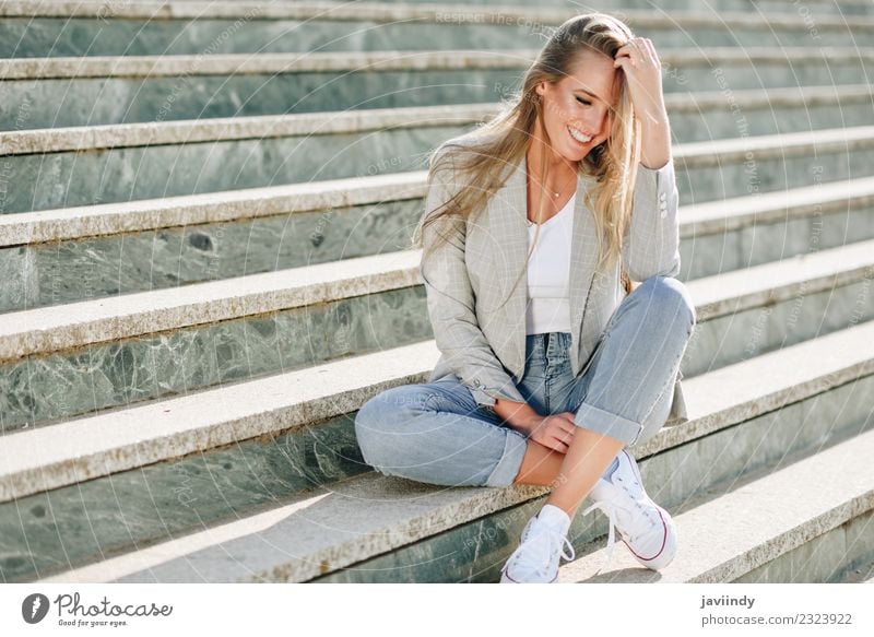 Blonde Frau lächelnd sitzend in städtischen Stufen sitzend Lifestyle schön Mensch feminin Junger Mann Jugendliche Erwachsene 1 18-30 Jahre Straße Mode