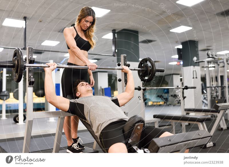 Weiblicher Personal Trainer, der einem jungen Mann hilft, Gewichte anzuheben. Lifestyle Körper Sport Mensch Junge Frau Jugendliche Junger Mann Erwachsene 2
