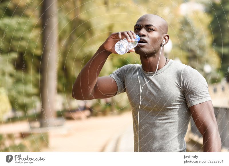 Junger schwarzer Mann trinkt Wasser, bevor er ins Freie läuft. trinken Flasche Lifestyle Körper Sport Joggen Mensch maskulin Junger Mann Jugendliche Erwachsene