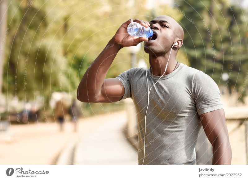 Junger schwarzer Mann trinkt Wasser, bevor er ins Freie läuft. trinken Flasche Lifestyle Körper Sport Joggen Mensch maskulin Junger Mann Jugendliche Erwachsene