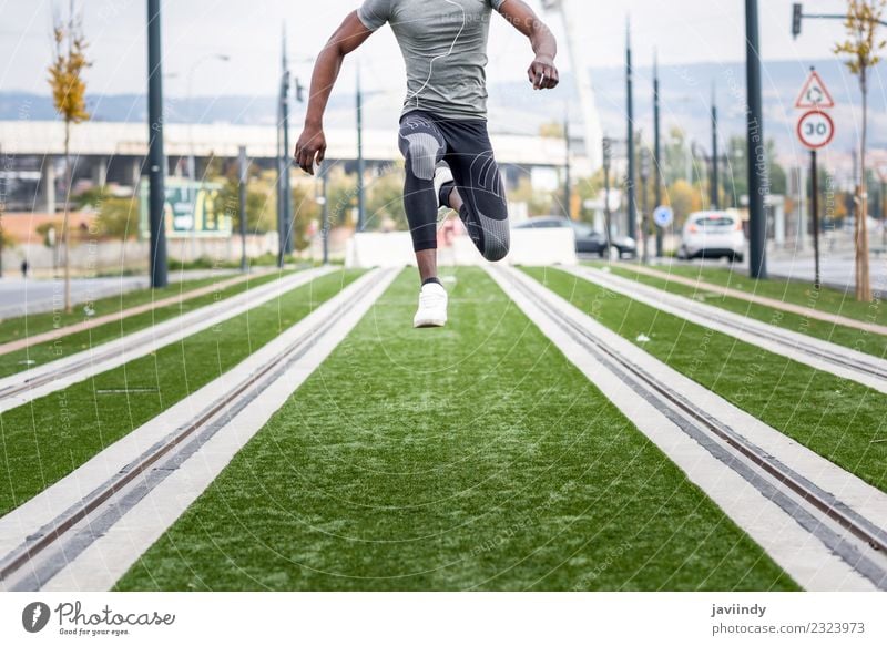 Ein schwarzer Mann, der im urbanen Hintergrund springt. Lifestyle Sport Joggen Mensch maskulin Junger Mann Jugendliche Erwachsene 1 18-30 Jahre Straße Fitness