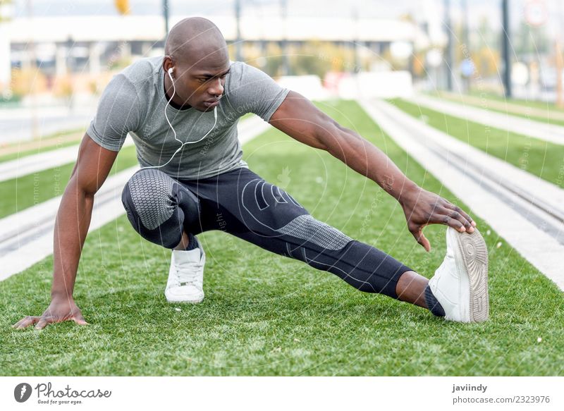 Schwarzer Mann, der sich dehnt, nachdem er im urbanen Hintergrund gelaufen ist. Lifestyle Körper Sport Joggen Mensch maskulin Junger Mann Jugendliche Erwachsene