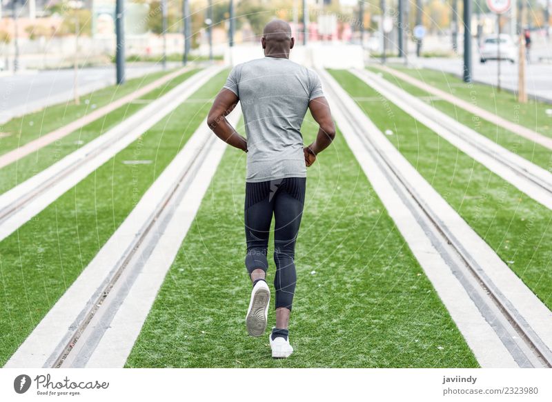 Rückansicht eines schwarzen Mannes, der im urbanen Hintergrund läuft. Lifestyle Körper Sport Joggen Mensch maskulin Junger Mann Jugendliche Erwachsene 1