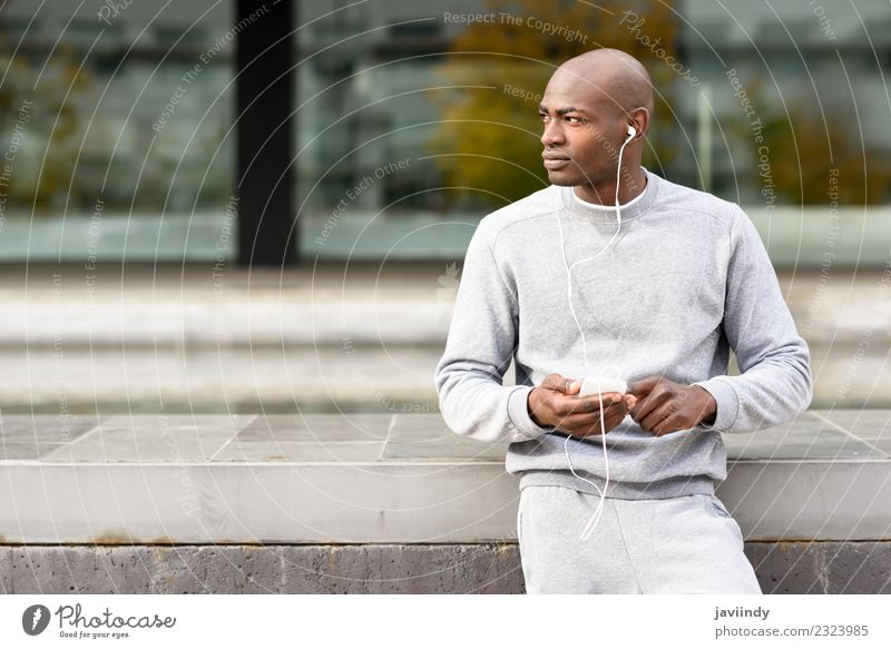 Attraktiver schwarzer Mann, der Musik mit Kopfhörern im Freien hört. Lifestyle Glück Sport Telefon PDA Technik & Technologie Mensch Junger Mann Jugendliche