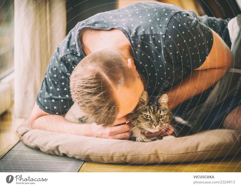 Mann schmust mit Katze Lifestyle Freude Leben Häusliches Leben Wohnung Mensch Junger Mann Jugendliche Erwachsene Tier Haustier Liebe gelb Gefühle Stimmung