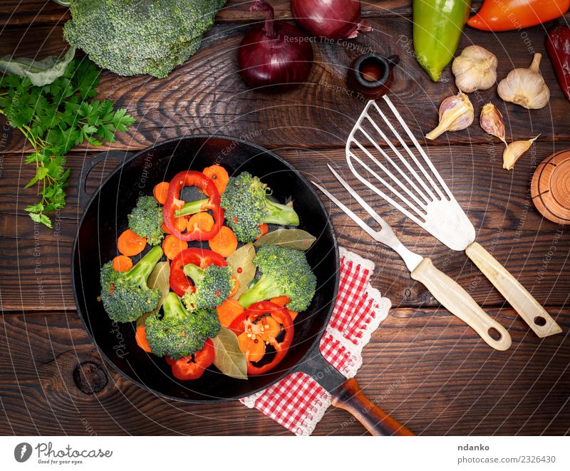 Gemüse in einer schwarzen runden Pfanne Ernährung Essen Vegetarische Ernährung Diät Gabel Tisch Küche Natur Pflanze Holz frisch natürlich braun grün rot