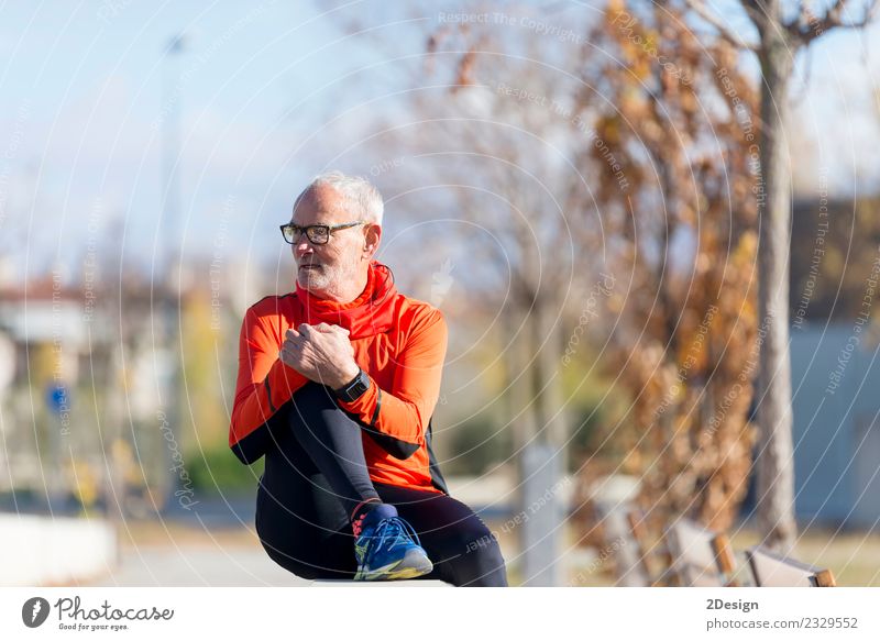 Senior-Läufer, der nach dem Joggen in einem Park sitzt. Lifestyle Glück Gesundheit sportlich Erholung ruhig Freizeit & Hobby Sommer Musik Sport Leichtathletik
