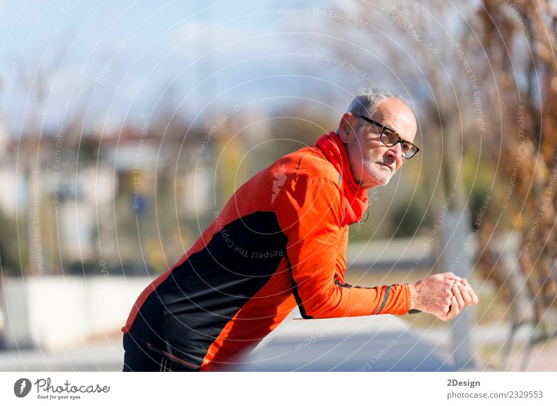 Athletischer Senior-Mann, der sich auf einen Zaun stützt. Lifestyle Körperpflege Gesundheitswesen sportlich Fitness Erholung Freizeit & Hobby Musik Sport
