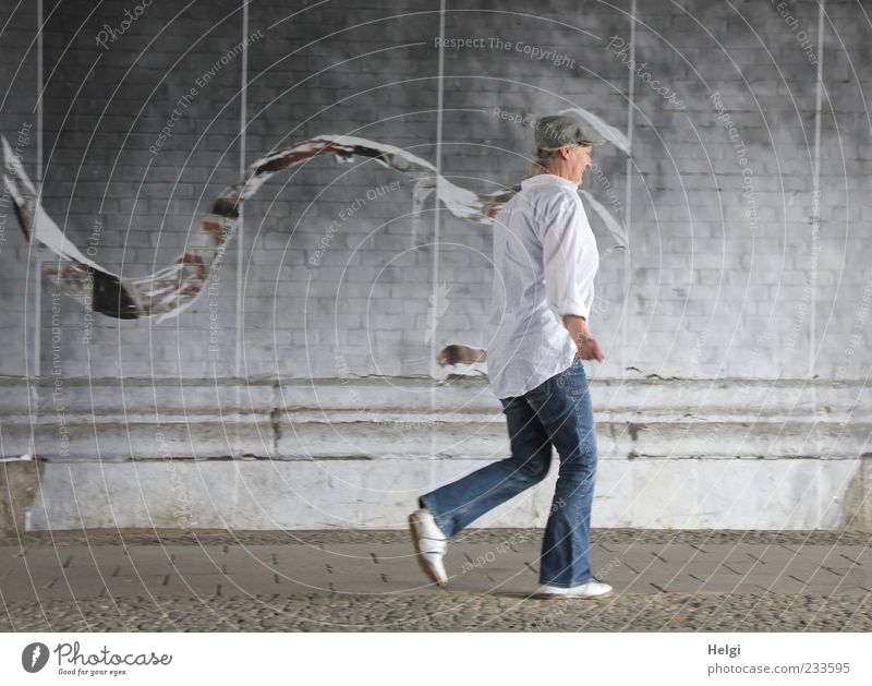 Frau mit Cap in Jeanshose und weißem Hemd läuft an einer Wand entlang Mensch Erwachsene Weiblicher Senior Leben 1 45-60 Jahre Tunnel Mauer Verkehrswege