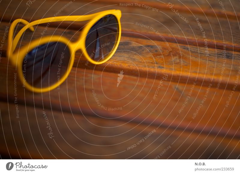 Sommersonnenbrille Lifestyle Tisch Holztisch Sonnenbrille braun gelb Gelassenheit Sommerurlaub sommerlich Farbfoto Außenaufnahme Menschenleer