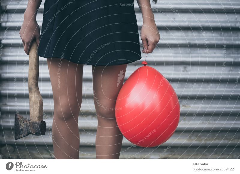 Teenagermädchen steht an einer Wand mit Ballon und Axt Lifestyle Körper Mensch Frau Erwachsene Jugendliche Hand Park Mode Luftballon Traurigkeit warten rot